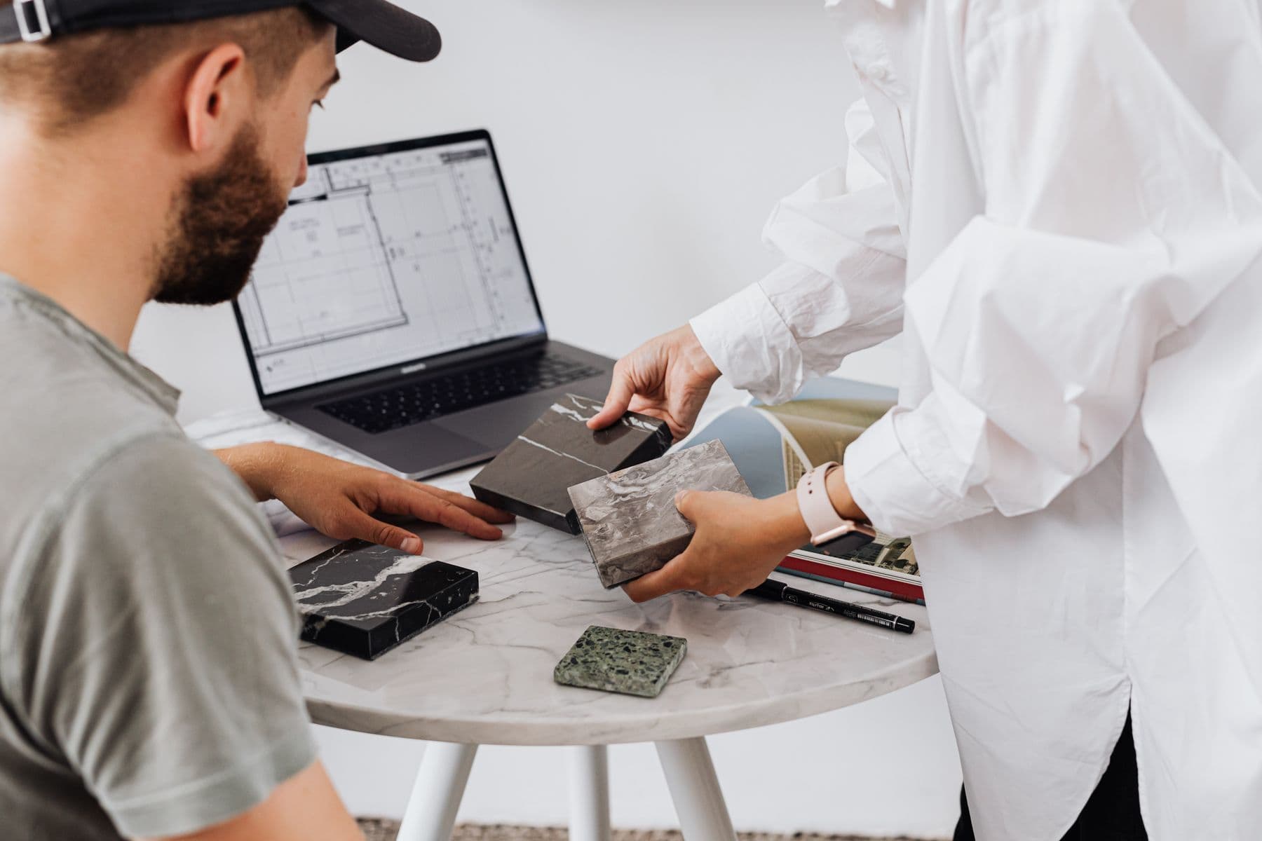 Two designers choosing marble and tile samples for a residential interior
